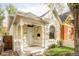 Charming yellow home featuring an inviting front porch with decorative white railings and a well-manicured lawn at 2909 Glenarm Pl, Denver, CO 80205