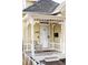 This home features a cozy front porch with decorative white pillars, trim, and a seating area at 2909 Glenarm Pl, Denver, CO 80205
