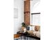 Cozy living room featuring a brick wall, a comfortable sofa, and a round accent table at 2909 Glenarm Pl, Denver, CO 80205