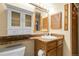 Bathroom featuring vanity with mirror and lighting, cabinets, sink, and a toilet below at 8225 Fairmount Dr # 102, Denver, CO 80247