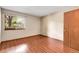 Bedroom featuring hardwood floors, a window with natural light, and a closet door at 8225 Fairmount Dr # 102, Denver, CO 80247