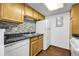 Kitchen featuring wood cabinets, a white refrigerator and black countertops at 8225 Fairmount Dr # 102, Denver, CO 80247
