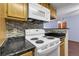 Kitchen featuring wood cabinets and white appliances at 8225 Fairmount Dr # 102, Denver, CO 80247