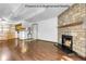 Open-concept living room with cozy fireplace and hardwood floors at 8225 Fairmount Dr # 102, Denver, CO 80247