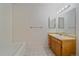 Bathroom featuring a tub and shower, a vanity with a sink, and a large mirror at 8438 Everett Way # B, Arvada, CO 80005