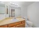 Full bathroom with a mirrored wall, a single sink vanity, and a toilet at 8438 Everett Way # B, Arvada, CO 80005