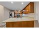 Efficient kitchen featuring wood cabinets, modern appliances, and a breakfast bar at 8438 Everett Way # B, Arvada, CO 80005