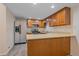 Well-equipped kitchen with stainless steel appliances, wood cabinetry, and breakfast bar at 8438 Everett Way # B, Arvada, CO 80005