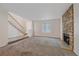 Cozy living room features a stone fireplace, staircase and carpet at 8438 Everett Way # B, Arvada, CO 80005