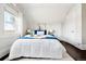 Cozy bedroom with white comforter, hardwood floors, and bright natural light from the window at 1484 Cherry St, Denver, CO 80220