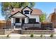 Charming two-story home with black trim, well-maintained lawn, and a cozy, fenced front patio at 1484 Cherry St, Denver, CO 80220