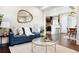 Open living room with dark wood floors, blue sofa, and view into kitchen and dining area at 1484 Cherry St, Denver, CO 80220