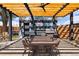 Outdoor kitchen features a mural, pergola, dining table, grill, and bar with seating for outdoor entertaining at 1484 Cherry St, Denver, CO 80220