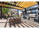 Outdoor kitchen features a mural, pergola, dining table, grill, and a fire pit for entertaining guests at 1484 Cherry St, Denver, CO 80220