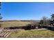 Expansive backyard featuring well-maintained lawn, wooden fence, gardening beds and pergola with beautiful field views at 14259 W Virginia Dr, Lakewood, CO 80228