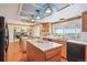 Bright kitchen featuring an island, wooden cabinetry, and views of the surrounding landscape at 14259 W Virginia Dr, Lakewood, CO 80228