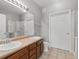 Bathroom with double sinks, vanity, framed mirror, toilet, and tiled shower with glass door at 9633 E 5Th Ave # 10208, Denver, CO 80230