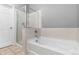 A tub and shower combination features neutral tiling and a glass door at 9633 E 5Th Ave # 10208, Denver, CO 80230