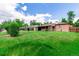 Large backyard with green grass, brick home, and privacy fence at 3334 W Grand Ave, Englewood, CO 80110