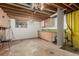 Unfinished basement features exposed wood ceiling beams, utility sink, and concrete flooring at 3334 W Grand Ave, Englewood, CO 80110