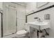 Bathroom featuring a sink with silver faucet, black and white floor tiles, and a shower with sliding door at 3334 W Grand Ave, Englewood, CO 80110