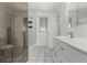 Bright bathroom with a tub shower, white tiled floors, mirrored closet and single sink vanity at 3334 W Grand Ave, Englewood, CO 80110