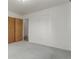 Bedroom with light gray carpeting, closet, white walls, and doorway to another room at 3334 W Grand Ave, Englewood, CO 80110