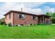 Brick home featuring a well-maintained lawn, manicured shrubs, and a cozy covered porch at 3334 W Grand Ave, Englewood, CO 80110