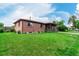 Brick home featuring a well-maintained lawn, manicured shrubs, and a cozy covered porch at 3334 W Grand Ave, Englewood, CO 80110