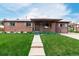 A quaint single-story brick home with a well-manicured lawn, covered porch, and walkway at 3334 W Grand Ave, Englewood, CO 80110