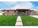A quaint single-story brick home with a well-manicured lawn, covered porch, and walkway at 3334 W Grand Ave, Englewood, CO 80110