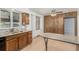 Spacious kitchen with granite counters, wood cabinets, and stainless steel sink under a bright window at 3334 W Grand Ave, Englewood, CO 80110