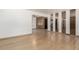 Expansive living area featuring hardwood floors, wall mirrors, and a peek into an adjacent room at 3334 W Grand Ave, Englewood, CO 80110