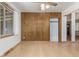 Bright living room featuring hardwood floors, wood paneling, and a large window for natural light at 3334 W Grand Ave, Englewood, CO 80110