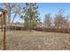 View of the backyard featuring mature trees, and a wood fence with a grass and leaf ground covering at 3937 S Truckee St, Aurora, CO 80013