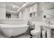 Bright bathroom featuring a luxurious clawfoot tub, stylish pedestal sink, and modern toilet at 3937 S Truckee St, Aurora, CO 80013