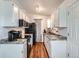 Galley kitchen with white cabinets, modern appliances, and hardwood flooring at 3937 S Truckee St, Aurora, CO 80013