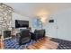 Cozy living room with a stone fireplace, hardwood floors, and comfortable seating at 3937 S Truckee St, Aurora, CO 80013