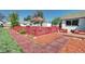 A spacious backyard perfect for entertaining with an umbrella, red fence and patio at 2401 W Jewell Ave, Denver, CO 80219