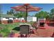 Cozy backyard with a patio set, red fence, and umbrella offering shade for outdoor relaxation at 2401 W Jewell Ave, Denver, CO 80219