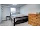 Bedroom with a black wooden bed frame, plush carpet, and dresser at 2401 W Jewell Ave, Denver, CO 80219