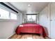 Cozy bedroom featuring natural light, hardwood floors, and painted block walls at 2401 W Jewell Ave, Denver, CO 80219