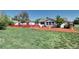 Charming home featuring a well-maintained lawn and inviting front porch with a red fence at 2401 W Jewell Ave, Denver, CO 80219