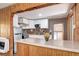 Bright kitchen featuring white cabinetry, colorful backsplash, stainless appliances and a peninsula countertop at 2401 W Jewell Ave, Denver, CO 80219