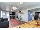 Open-concept living room showcasing hardwood floors, fireplace, and seamless access to kitchen at 2401 W Jewell Ave, Denver, CO 80219