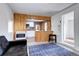 View of the living room with wood paneled accent walls, a kitchen pass-through, and comfortable seating at 2401 W Jewell Ave, Denver, CO 80219