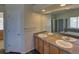 Bathroom with double sinks, a large mirror, and a view of the bathtub and shower at 331 Las Lomas St, Brighton, CO 80601