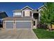 Two-story home with a three car garage, stone accents, and mature lawn at 331 Las Lomas St, Brighton, CO 80601