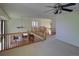 Bright hallway with natural lighting, wood railing, neutral carpet, and a view into the kitchen at 331 Las Lomas St, Brighton, CO 80601