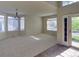 Bright living room with neutral carpet, many windows, and access to the back yard at 331 Las Lomas St, Brighton, CO 80601